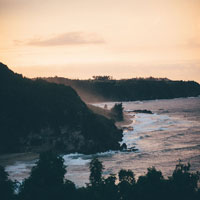 a wide view of the beach against cliffs and hills